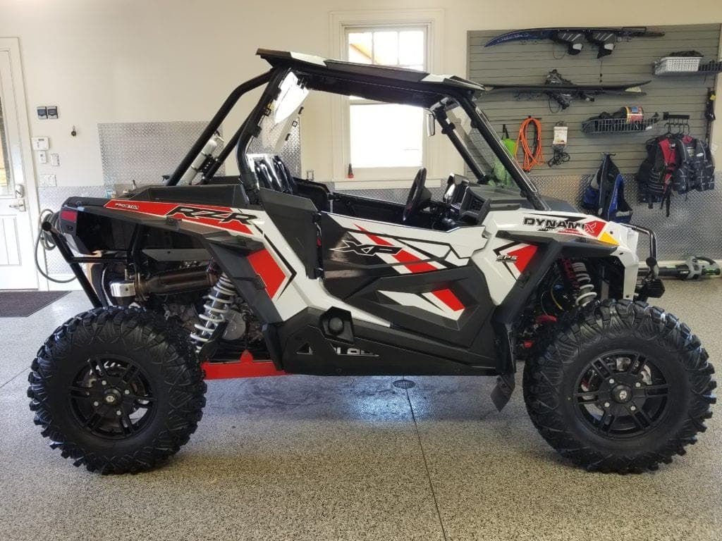 A white and red atv is parked in a garage.