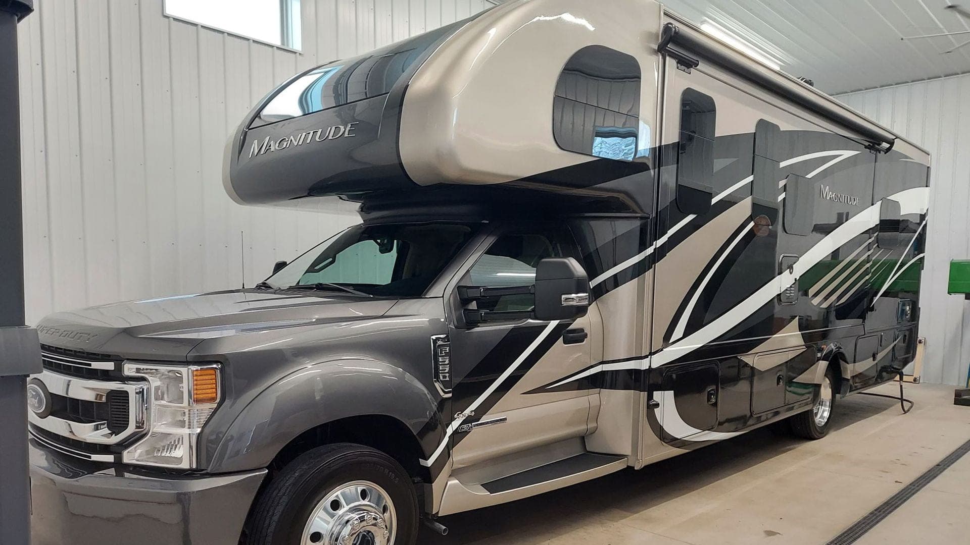 Gray and tan Class C motorhome parked inside a garage